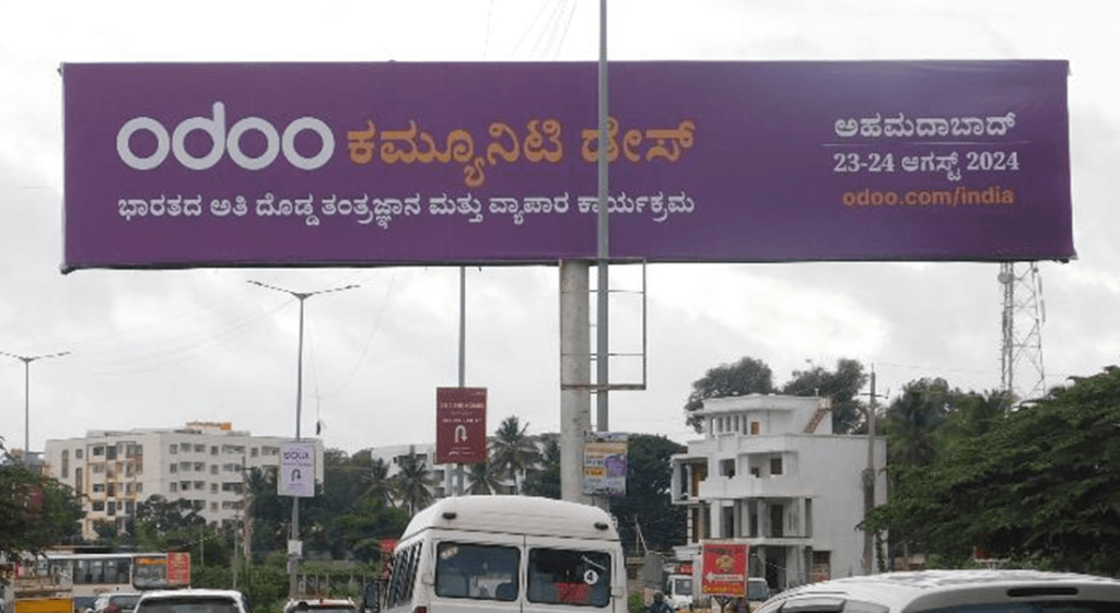 Large roadside billboard displaying a bright advertisement for a fashion brand with a model wearing a stylish outfit.
