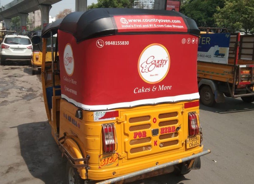 Auto Advertising Service showcasing branded auto rickshaw promoting bakery brand in city traffic