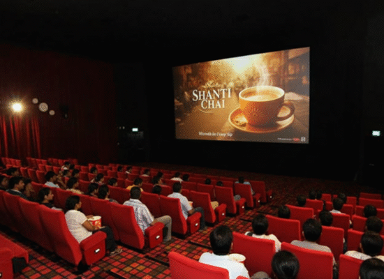 Audience in a cinema theater watching a Shanti Chai cinema ad with steaming tea and the tagline Warmth in Every Sip.